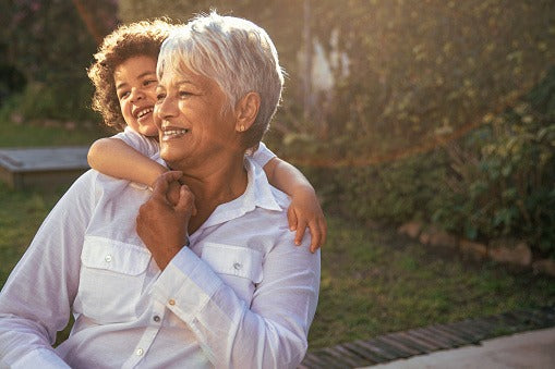 A woman carrying her laughing grandchild on her shoulders