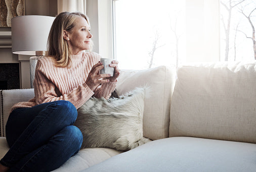 A radiant woman in her late fifties with healthy skin and silver hair